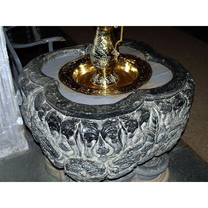 with the quatrefoil-shaped upper rim  -- notice that the font had an open interior; it has now been blocked by a wooden frame -seen here painted grey- that supports the baptismal dish