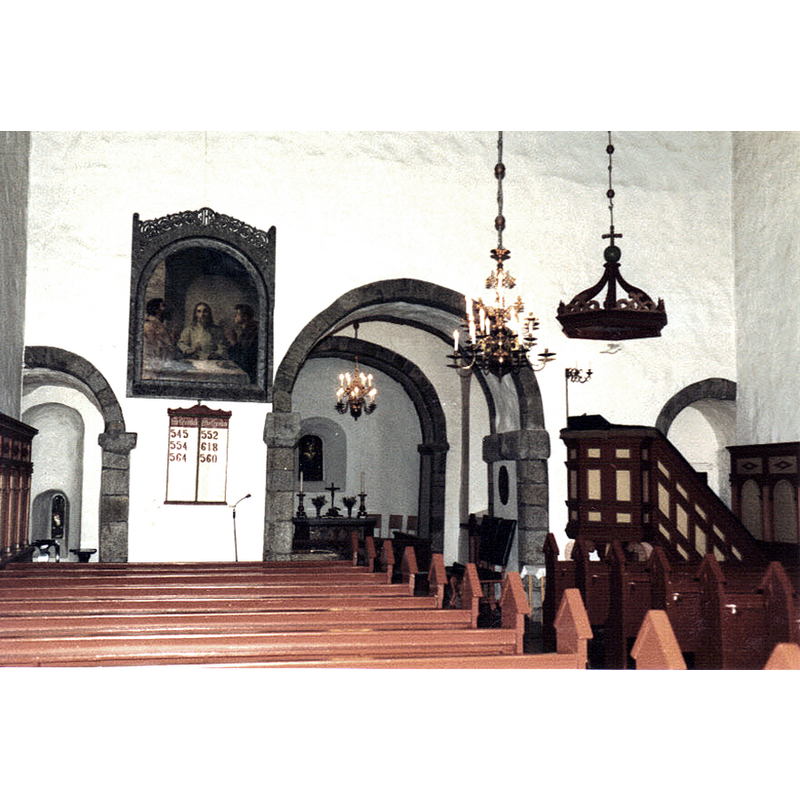 the top of the font and the baptismal dish can be discerne at the fron of the bank of benches, in line with the north side of the chancel arch