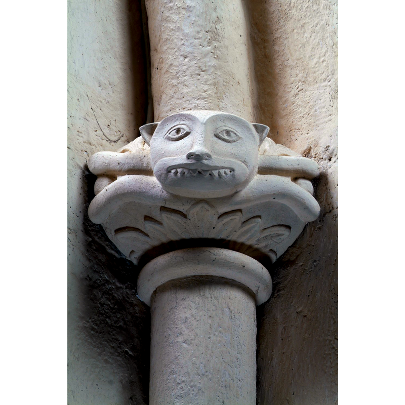Source caption: "Seul le chœur et les deux chapelles qui le flanquent sont couverts de voûtes et datent de la fin du XII e siècle. Deux curieux chapiteaux en calcaire attestent la fantaisie créatrice des imagiers romans."