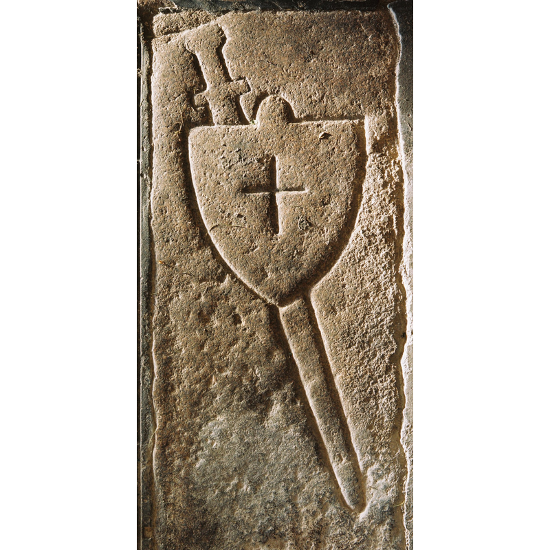 Source caption: "Cette petite paroisse était, à la fin du XIIIe siècle, propriété de l’Ordre du Temple. Elle passa, vers 1311, à celui de Malte. La dalle funéraire d’un chevalier atteste cette appartenance. Elle est taillée dans le grès qui a aussi servi à sculpter la croix, dont il ne reste qu’un fragment, jadis à l’entrée du cimetière, le bénitier et le fruste décor architectural."