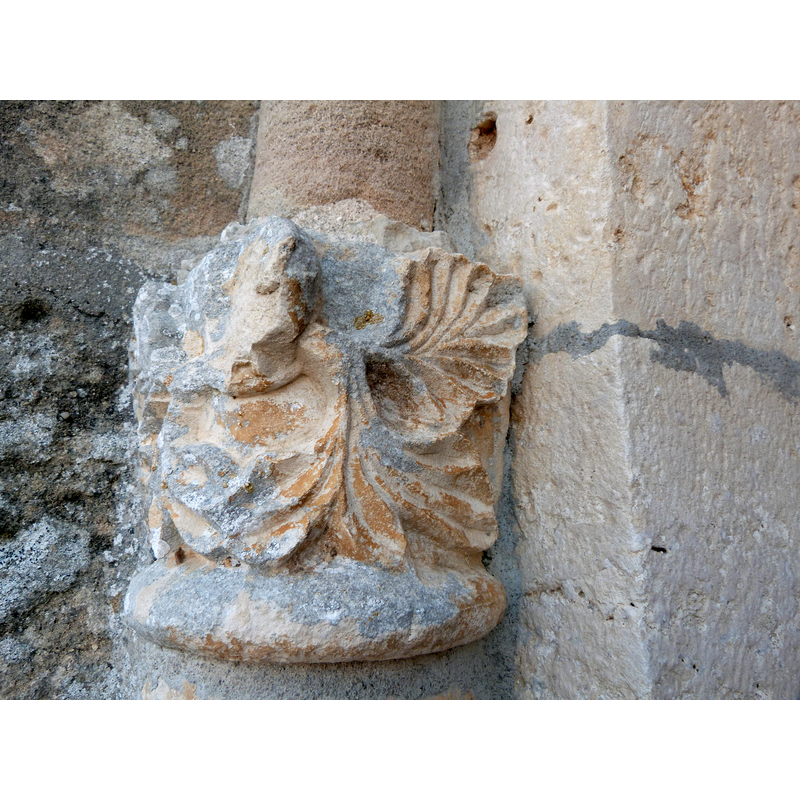 Jugeat Saint-Gilles -- Source caption: "Sculpture endommagée sur laquelle repose la moulure demi-cylindrique du portail. Il s'agirait d'un lion avec des palmettes sortant de la gueule."