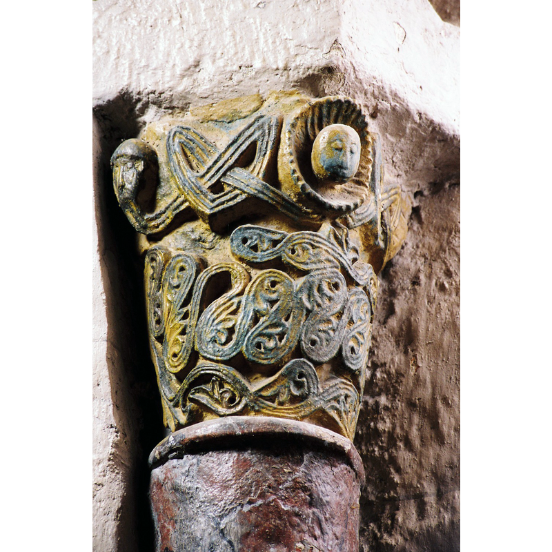 Source caption: "Le décor sculpté comporte des chapiteaux en calcaire, dans l’abside et les absidioles, et d’autres en granit, au niveau du transept Ils sont essentiellement ornés d’entrelacs et de palmettes."