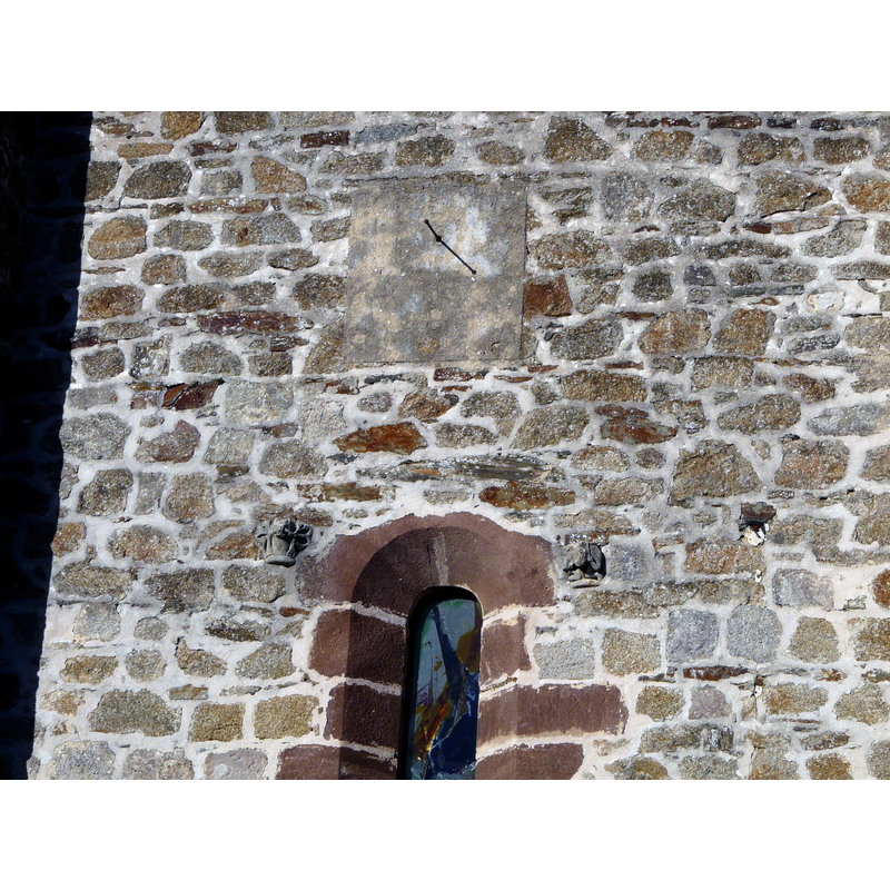 actual orientation is southwest -- Source caption: "Cadran solaire et bas-reliefs, façade occidentale, église d'Orgnac-sur-Vézère, Corrèze, France." -- two of the embedded objects are former capitals