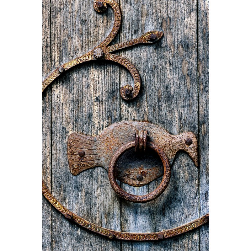 Source caption: "Les battants de la porte ont conservé leurs pentures en fer forgé du XIIe siècle."