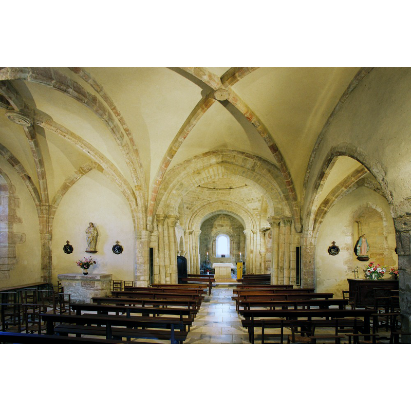 Source caption: "Le petit édifice roman a gardé son caractère, à l’exception de deux chapelles latérales tardives : coupole et arcatures géminées sous arcades, petites fenêtres, corniches saillantes, chapiteaux historiés d'une facture assez fruste."