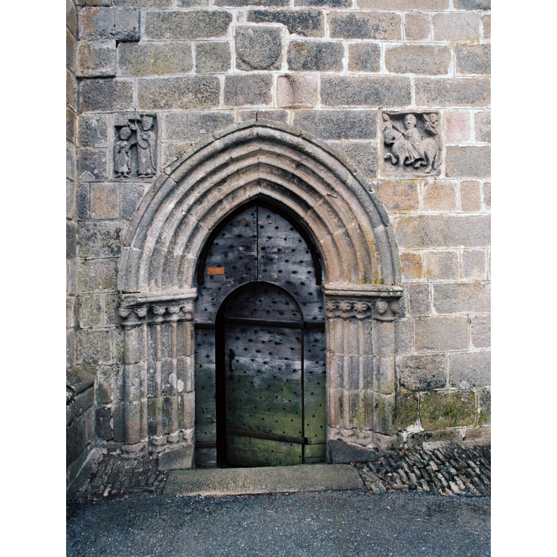 Source caption: "L’accès à l’église se fait, au nord, par un portail décoré de plusieurs archivoltes. De part et d’autre ont été encastrés deux bas-reliefs, accompagnés d’inscriptions, provenant de l’édifice primitif."