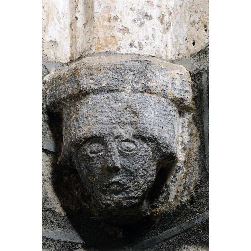 Source caption: "L’église, connue dès le XIe siècle, a été construite en style roman, conservé dans l’avant chœur. Le chevet, à mur droit, est voûté en style gothique flamboyant., ainsi que les deux chapelles formant transept. Les consoles sur lesquelles reposent les nervures sont ornées de curieux masques."