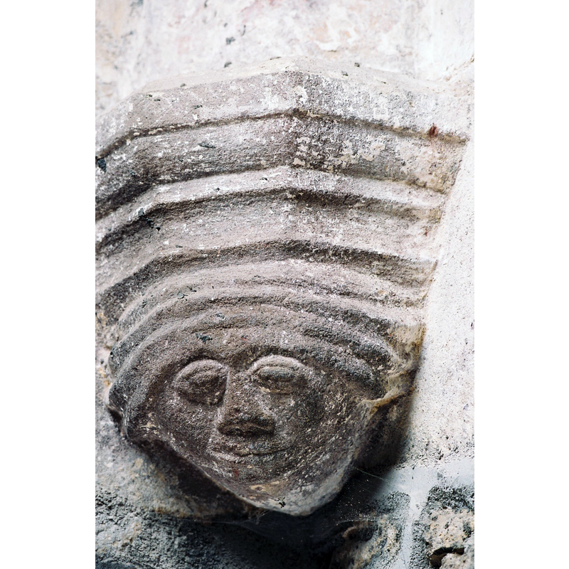 Source caption: "L’église, connue dès le XIe siècle, a été construite en style roman, conservé dans l’avant chœur. Le chevet, à mur droit, est voûté en style gothique flamboyant., ainsi que les deux chapelles formant transept. Les consoles sur lesquelles reposent les nervures sont ornées de curieux masques."