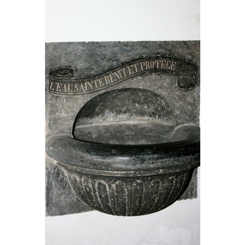 a modern wall-mounted stoup in this church