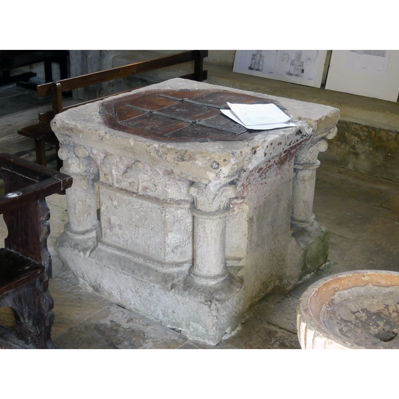 notice that the basin of the stoup to the right of the font has a large drain hole