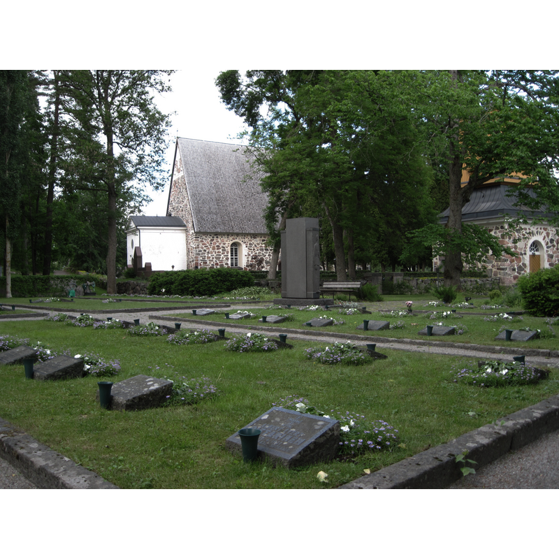 the church on the left and its bell tower on the right; in the foreground is a military cemetery