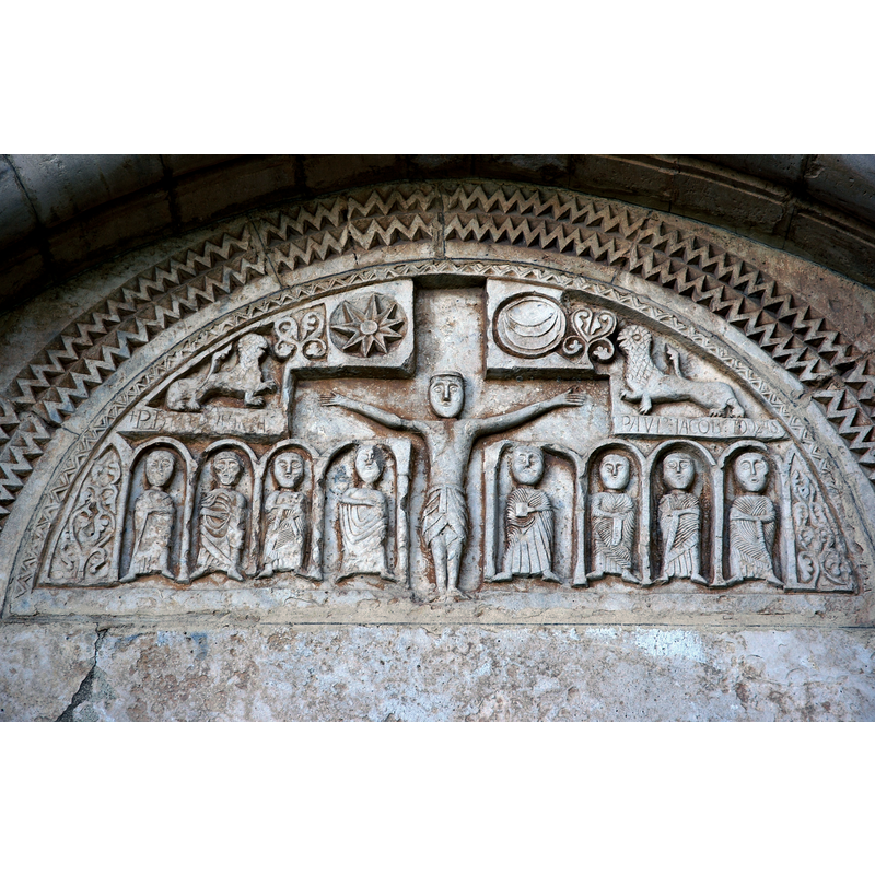 some of the incised inscriptions above the arcade that houses the Apostles can still be discerned, as can the attibutes of some of the figures