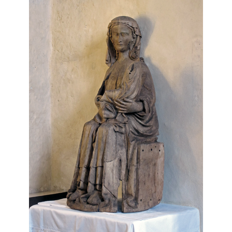 described in  Åsa Ringbom [www.kyrkor.ax/kyrkor/lemlands-kyrka/] [accessed 12 September 2017]: "Tronande Madonna med barnet från ca 1320 är kyrkans äldsta bevarade träskulptur, och samtidigt en av de förnämsta skulpturerna på Åland. Madonnan, som burit en gyllene krona, har varit rikt bemålad. Detalj av madonnans ansikte."