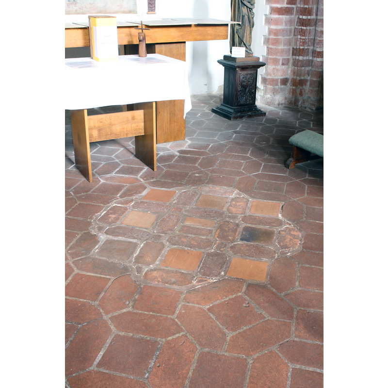 the markings on the ground suggests an earlier placing of a large object here; was it the base of the font?