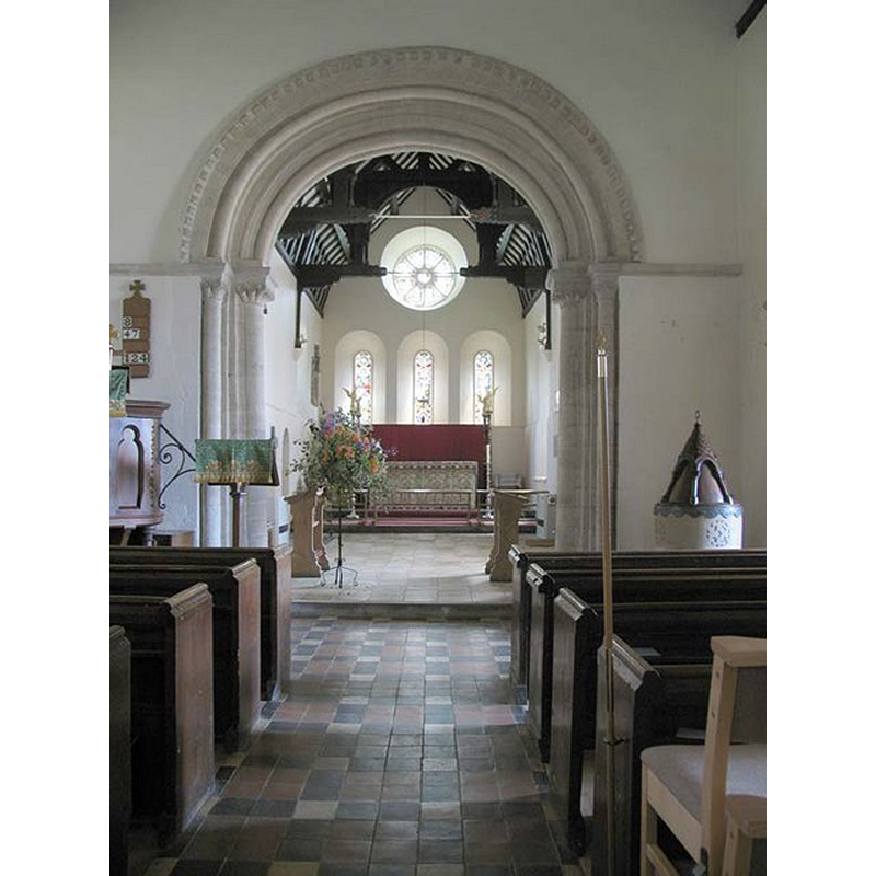 the font and cover partially visible at the east end of the nave, by the south side of the chancel arch