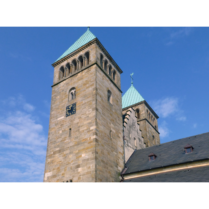 the saddle-back tower top has been preserved, dwarfed now by the 20thC twin towers