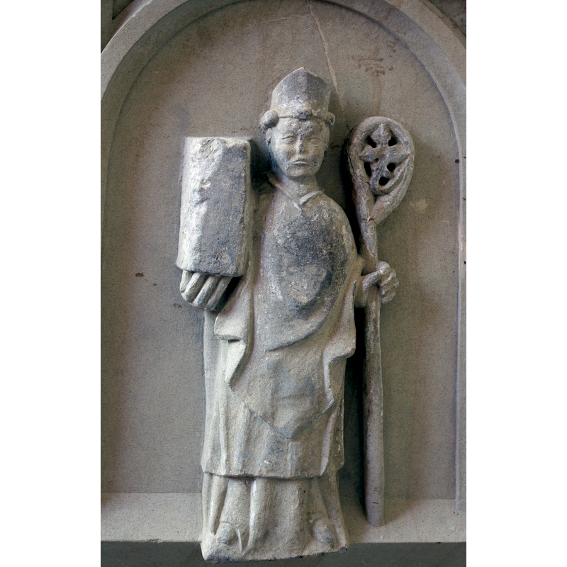 The figure here must be St. Fabianus, bishop of Rome (236-250), whose day is celebrated on 20 January, like St.Sebastian's, and whose body is buried in the church of San Sebastiano fuori le mura, in Rome [NB: both are patrons of this church and the font must have been expressedly been made for this church, adding the two patron saints to the Adoration scene] -- notice how the hem of the bishop's lower vestment wraps over the edge of the frame