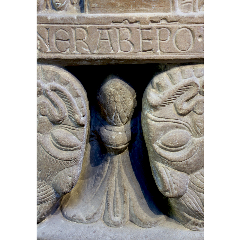 fine detail between the upturned lion heads below the inscription