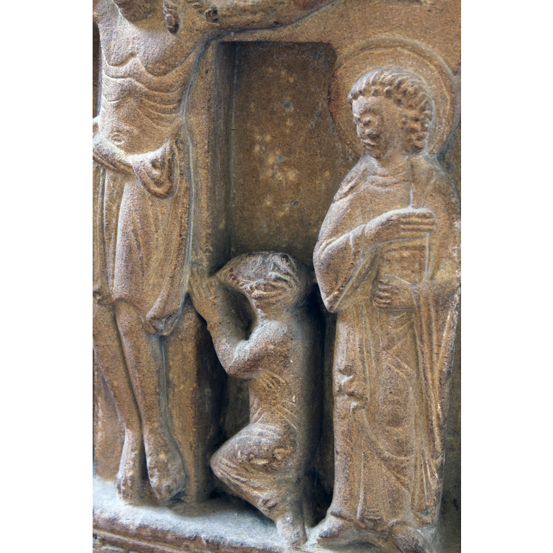 a bearded figure kneels to the left of the cross; a patron?