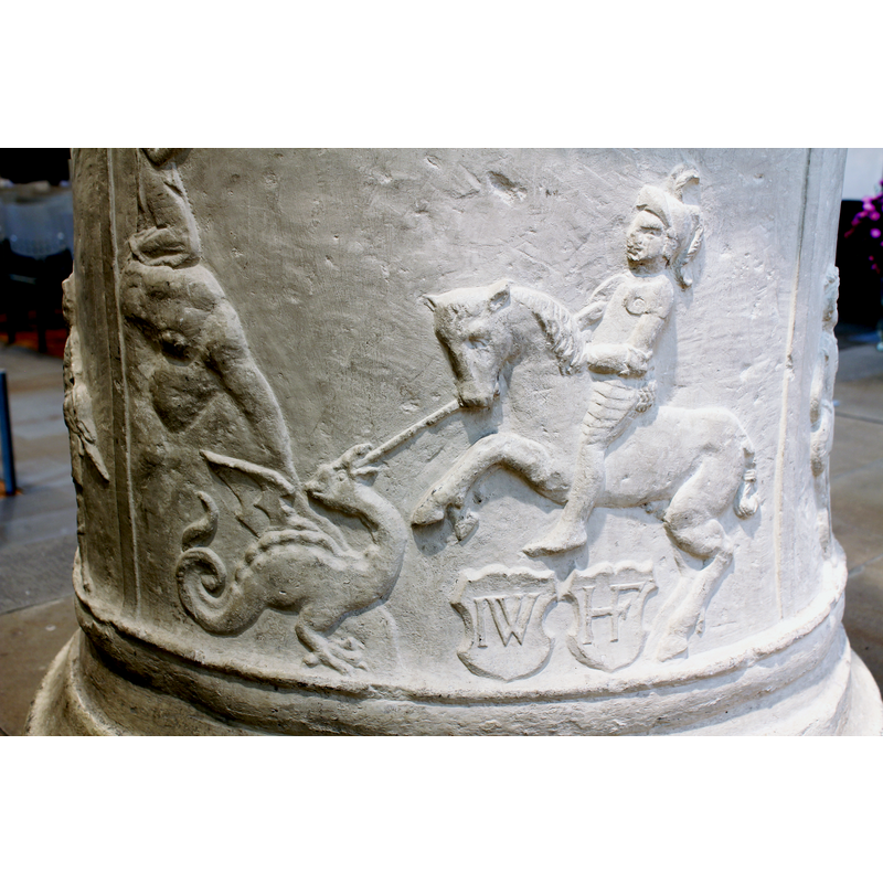 the St George and dragon scene is complemented by a kneeling figure on the cloud that appears to stem from the dragon's back, and by two shields chaged with sets of initials, below the horse