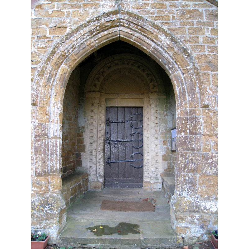 Source caption: "North door of church at Barford St. Michael, Oxfordshire. Gothic porch with Norman doorway.".