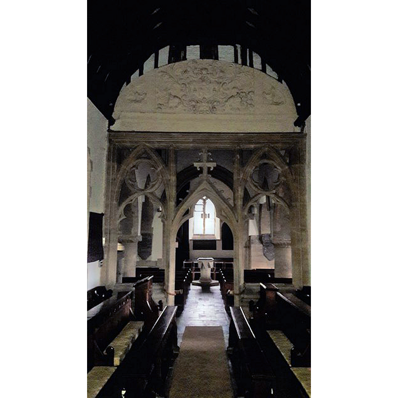 Source caption: "St Mary's North Leigh: view west. Behind the doom painting over the screen is this plaster relief with ANNA in the middle: royal arms of Queen Anne?"