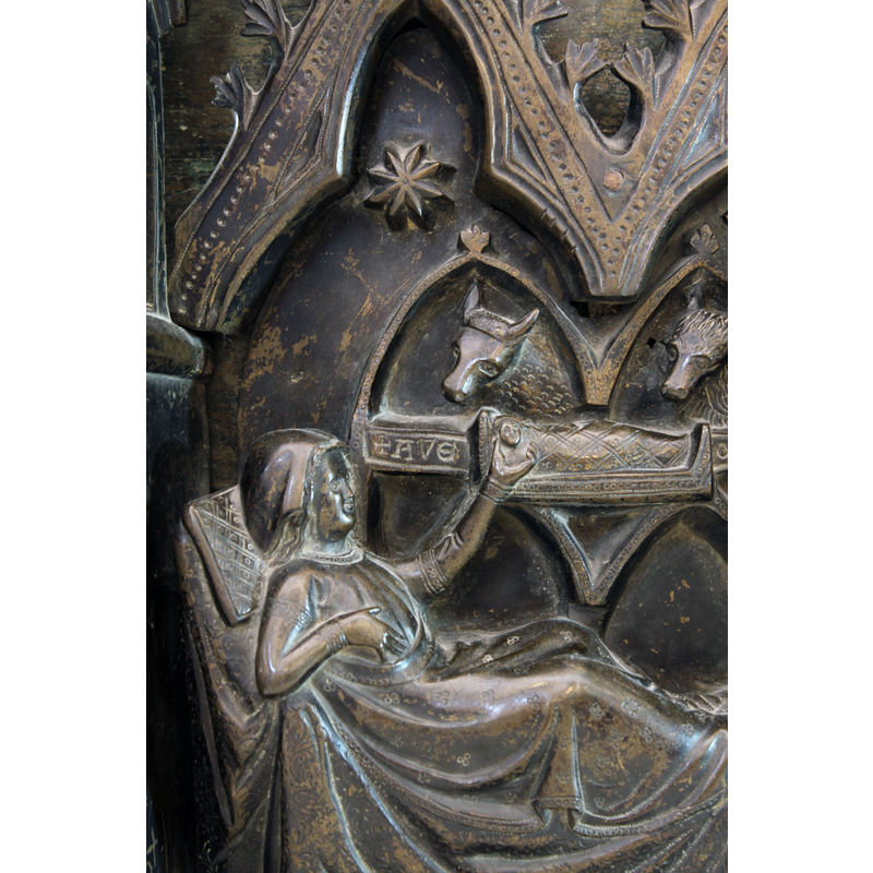 Mary appears comfortably reclined in her bed; her left hand cupping the tiny head of the child, whose body lies swathed on the manger; an inscription on the sides of the manger reads "+AVE MARIA"; the animals heads are framed in pointed arches; a 8-point star in the trefoiled arch-head above