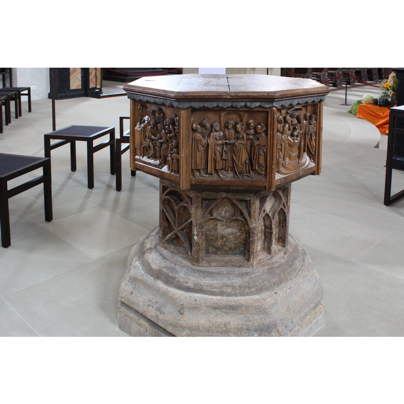 the modern wooden font showing three sacraments [L->R]: Confirmation, Marriage and Baptism, on the basin sides