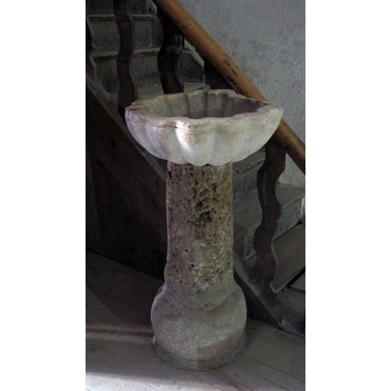 holy-water stoup located by the bottom of the stairs leading to the west gallery; it is of obvious composite nature, an old re-cycled pedestal supporting a shell-shaped basin