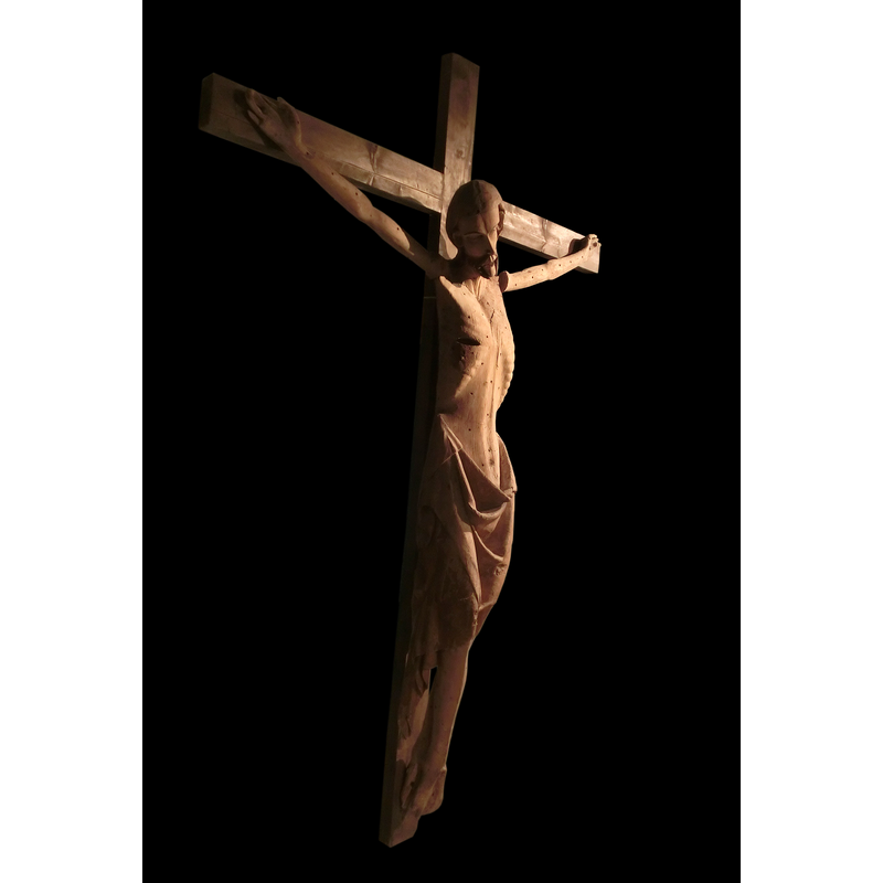 Source caption: "Triumfkrucifix från Skedby kyrka i Skeby socken, Kinnefjärdings härad, Götene kommun, f.d. Skaraborgs län, Skara stift, Västergötland, Västra Götalands län, Sverige. Kristus på korset är skulpterad i gotisk stil med utmärglad kropp och sår i sidan. Krucifixet är daterat till 1320-1350. Triumfkrucifix brukade placeras i övergången mellan långhus och kor. Krucifixet tillhör Västergötlands museum. Fotot taget i utställningen "Legenden Elin" på Skövde stadsmuseum sommaren 2013."