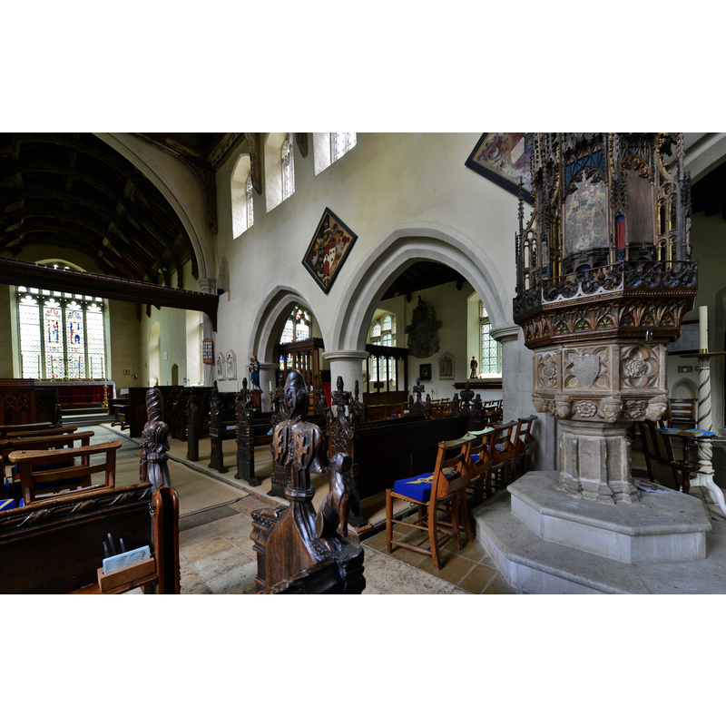 the font and cover rather distorted in the perspective -- Source caption: "Ufford: St. Mary of the Assumption Church: The font dating from 1450 and the profusion of bench ends".