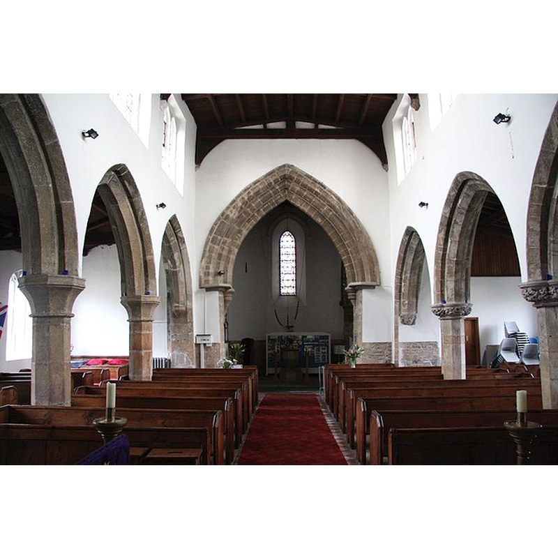 the font barely visible at the far back, in the tower space -- Source caption: "Large 12th century tower arch and 14th century arcades in All Saints' church"