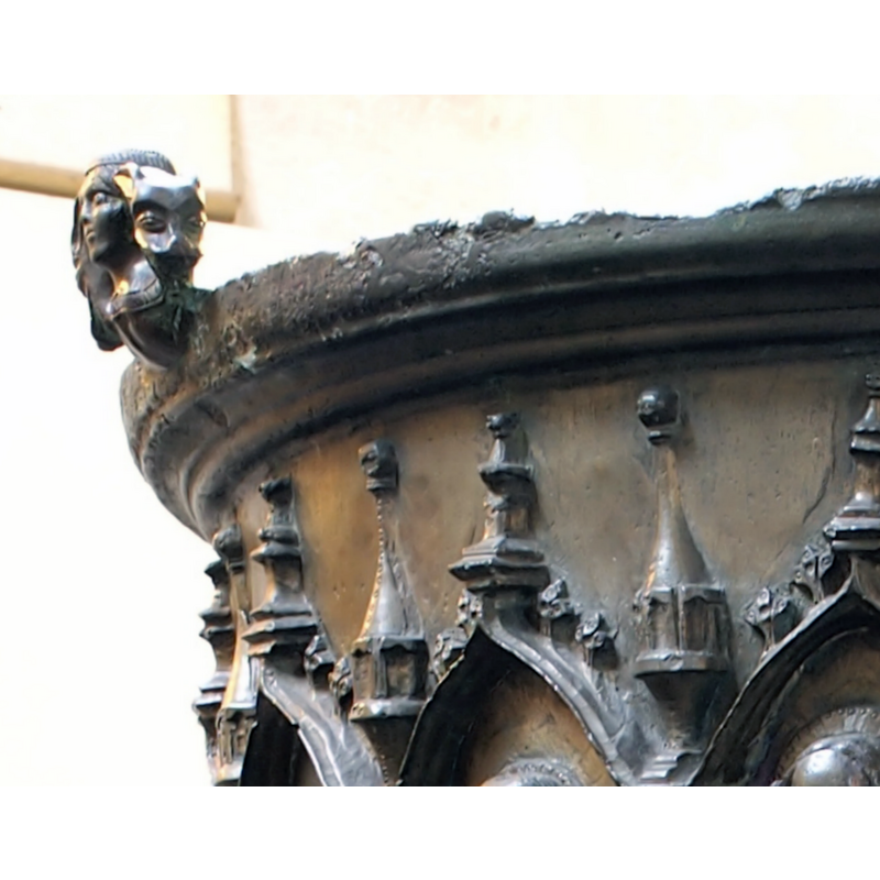 the bust of a female (?) figure has an animal head at each side of her face; the two busts served as anchorings for a now missing cover -- notice the damage to the upper rim area