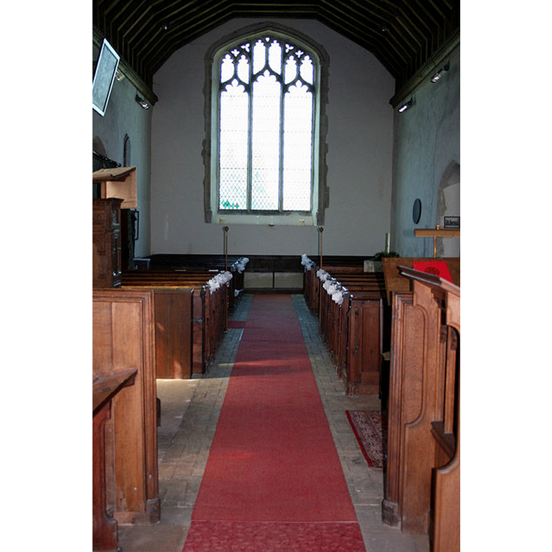 the baptismal font is partially visible in the far [west] right [north] corner of the nave