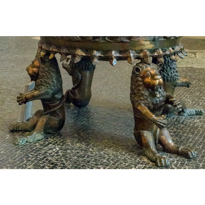 set at 90-degree angles and looking outwards; their front legs are set to hold something; their sitting posture is not leonine but human