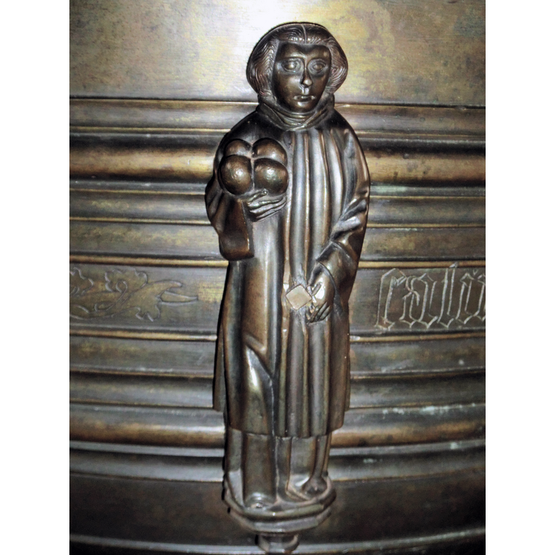 four round objects in his right hand help identify the figure; he is also the patron saint of this church