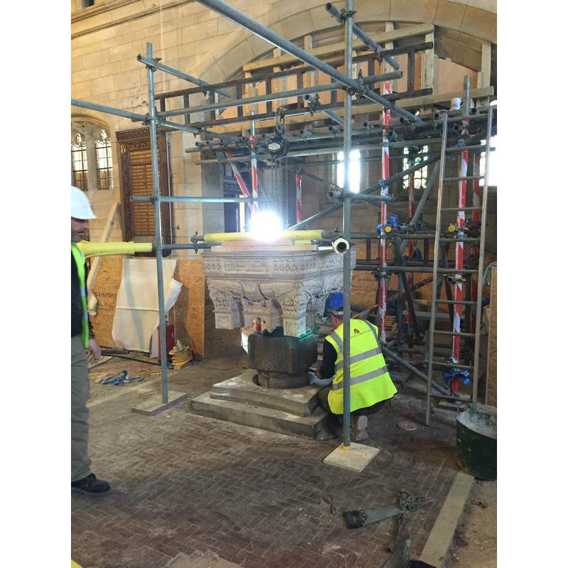 the old fonr has been fitted into the plinth socket; the new font is prepared to go into place