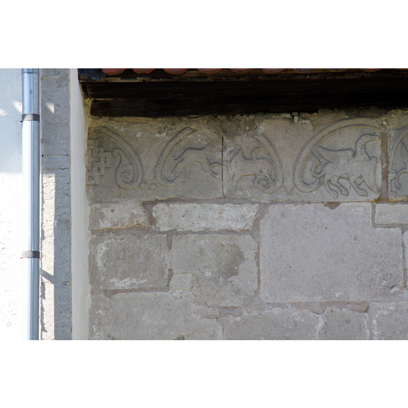 on the outer wall of the chancel, south side, right beneath the roof line