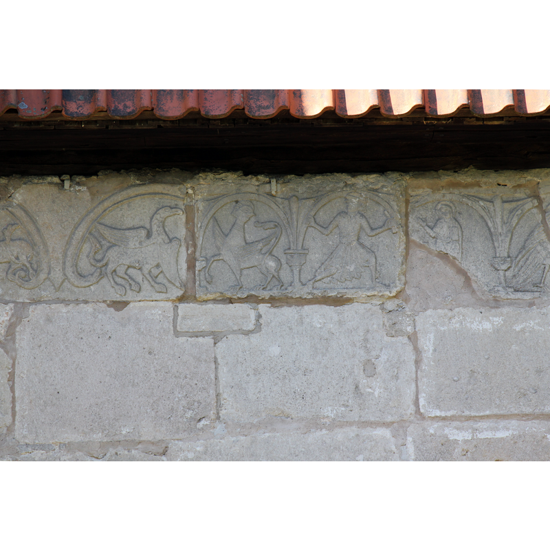 on the outer wall of the chancel, south side, right beneath the roof line