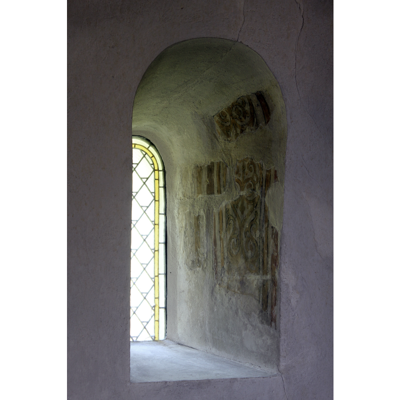one of three windows in the apse; remains of medieval painting on it