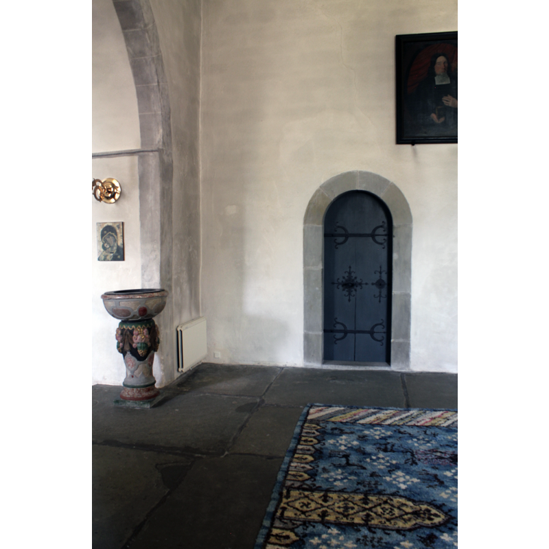 the font by the north side of the chancel arch; the sacristy door on the right