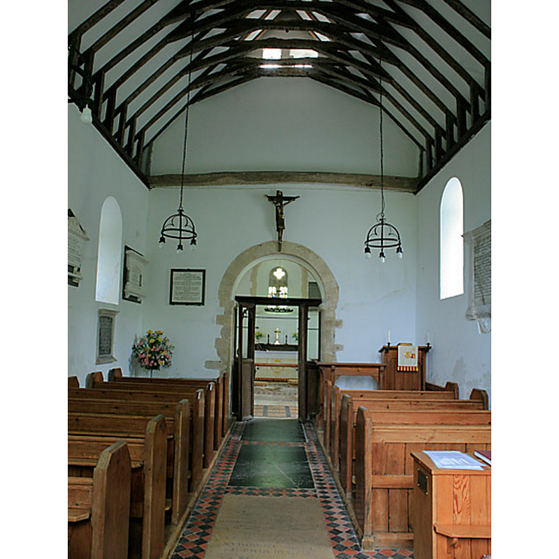 Source caption: "Interior of St Andrew's Church, Chilcomb. The church is dated to 1060 AD. Its architecture is very early Norman with Saxon influences in the unusual height in relation to its width, and in the two openings through the eastern gable of the nave, probably for bells."