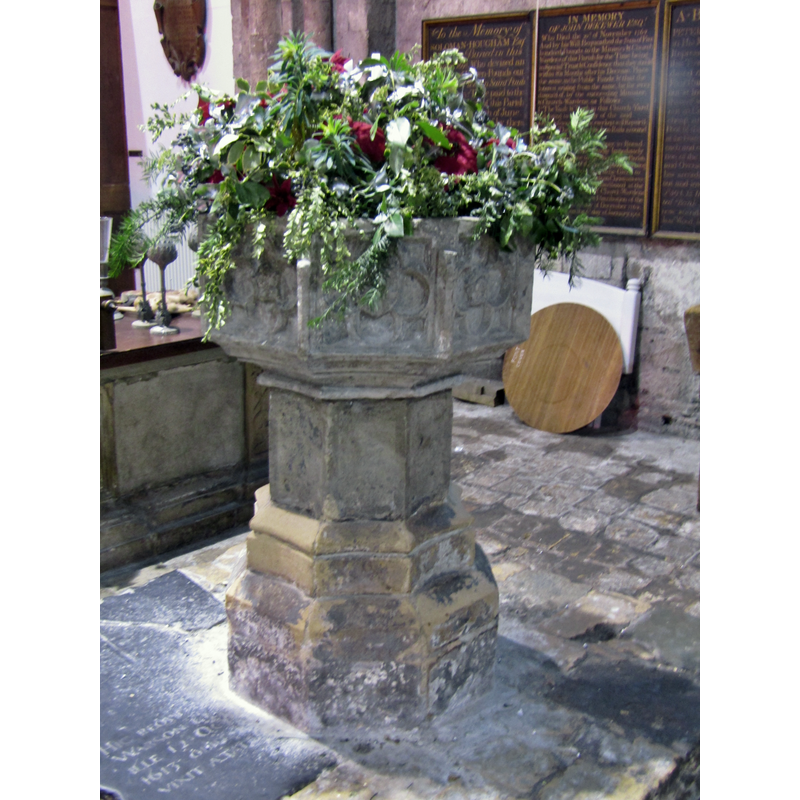 the modern round wooden cover is visible off the font, at the back, right side