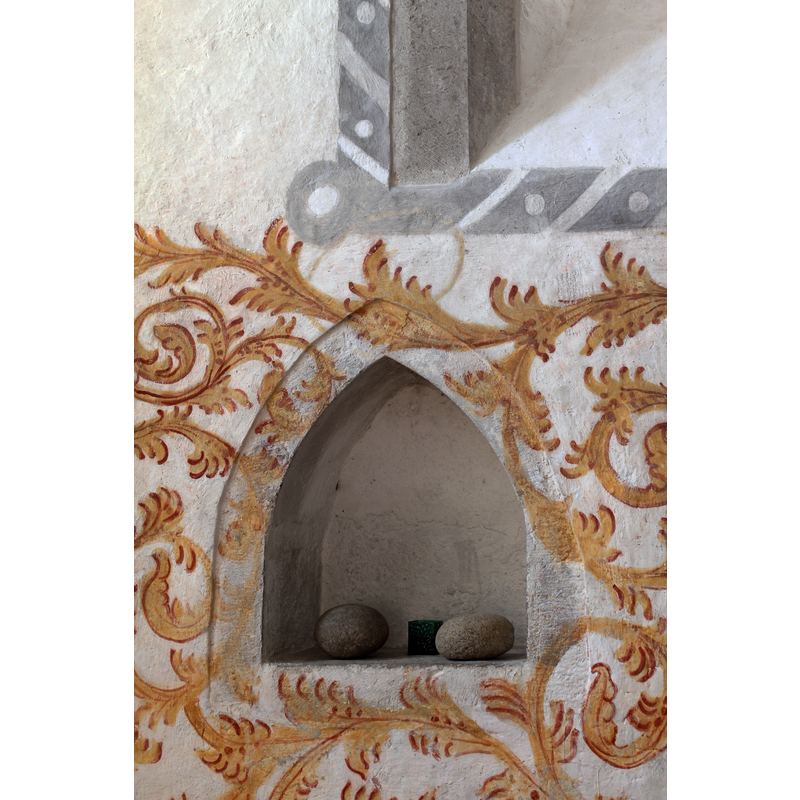 the two round stones in the little alcove are similar to the ones that were heated and used in the old days to warm the water in the fonts prior to infant baptisms in the North