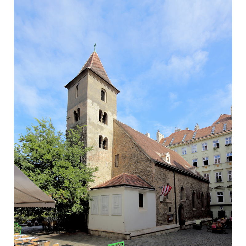Source caption: "Westansicht der Ruprechtskirche im 1. Wiener Gemeindebezirk Innere Stadt. Die Kirche ist dem Schutzpatron der Salzschiffer heiliger Rupert geweiht und ist die älteste noch bestehende Kirche der Stadt Wien. Das Langhaus und die unteren Geschoße des Turmes stammen weitgehendst aus dem 11/12. Jahrhundert. Sie befindet sich auf dem Gebiet des ehemaligen römischen Militärlagers Vindobona. Nach der Zerstörung der römischen Siedlung entstand die Keimzelle des späteren Wien im Bereich um die Ruprechtskirche. Sie war die Pfarre von Wien, bevor diese Funktion im Jahr 1147 an den Stephansdom überging."