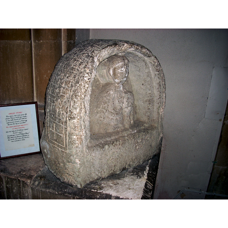 This church houses an interesting artifact  that may have originated in the early church here; it is described in the parish's site [www.allhallowswhitchurch.org.uk/History/AllHallows.aspx] [accessed 23 August 2018]: "The Saxon Stone. This stone was discovered embedded in the north wall when the Victorians were rebuilding the church in 1866-68. It is unique but reminiscent of the style of the stones found on Hadrian's Wall. It shows a carved figure in relief. The halo with the cross behind the head indicates that it is of Jesus, who holds the gospels in his left hand while his right is raised in blessing. In spite of the damage of centuries, the fingers are easily discernible. Like other very early representations of Christ, the chin, albeit damaged, seems to be clean-shaven. Across the top, and possibly at some later date, an inscription has been carved, commemorating a Saxon lady whose name means "Pledge of Peace". It reads: "HIC CORPUS FRITHBURGAE REQUIESCIT IN PACEM SEPULTUM", which is translated as: "Here the body of Frithburga lies buried in peace". Whoever she was, she represents the Saxon community of centuries ago."