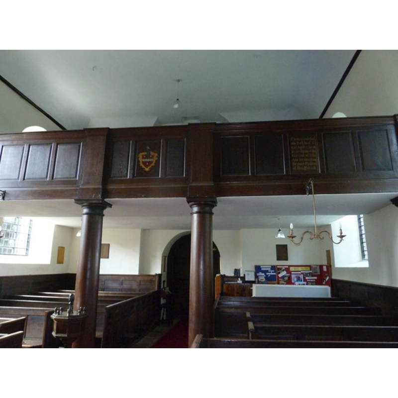 showing the west gallery; partial view of the wooden font in the foreground, left side
