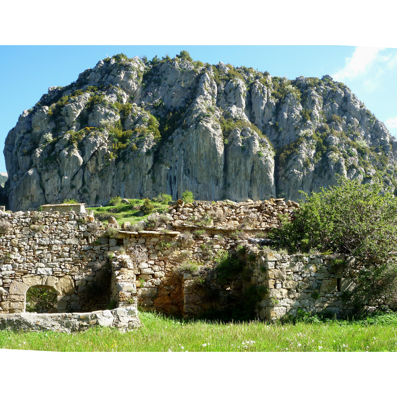 Source caption: "Església parroquial de Sant Miquel (Fígols) amb el Roc de Peguera al fons"