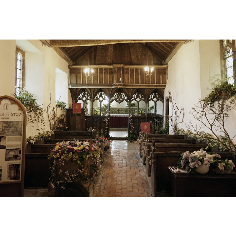 the font in the foreground, left side, covered in flowers and foliage