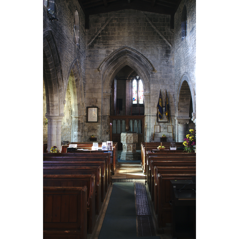 Source caption: "The octagonal font has part C15 stem with panels in part bearing pointed arches containing sacred symbols and floriate designs, and also C12 billet moulded blank arcading, the panels filled with fleurons and trefoils. The C19 bowl repeats this theme."